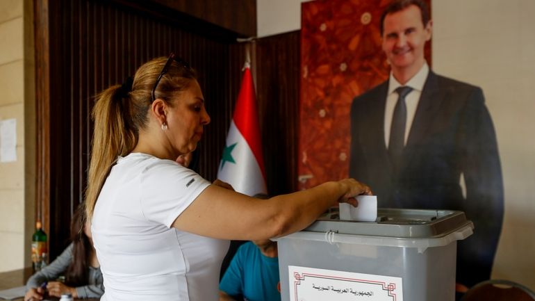 A Syrian woman casts her vote at a polling station...