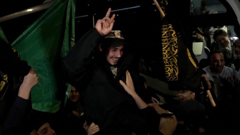 Palestinian Abdulkareem Abu Mustafa waves after being released from prison...