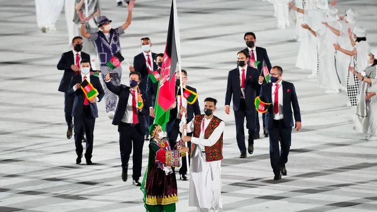 Kimia Yousofi, front left, and Farzad Mansouri, of Afghanistan, carry...