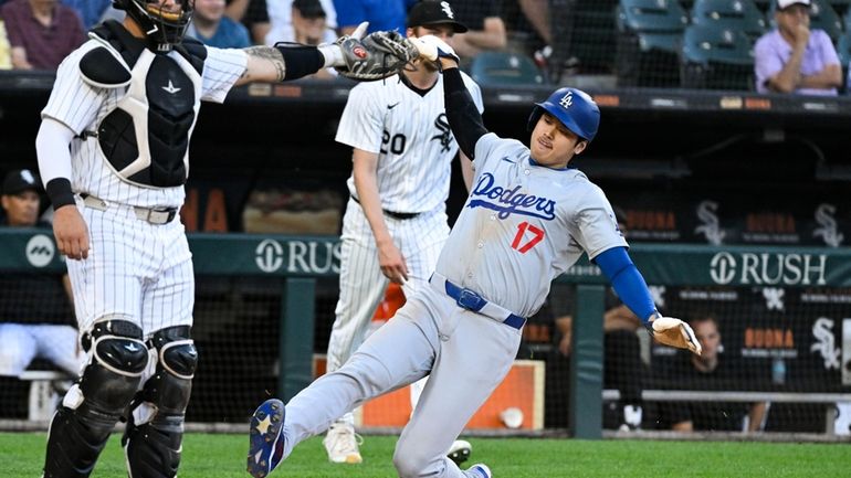 Los Angeles Dodgers designated hitter Shohei Ohtani scores against the...