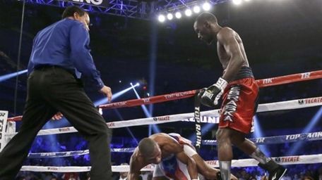 Terence Crawford, right, stands over Thomas Dulorme after