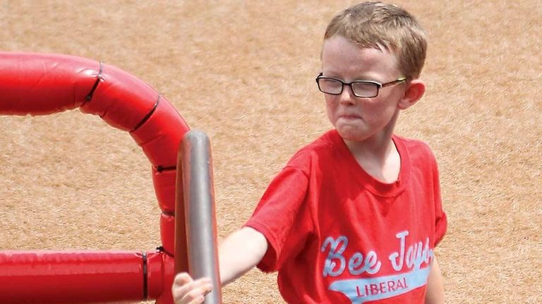 Bat boy Kaiser Carlile, 9, gets ready for