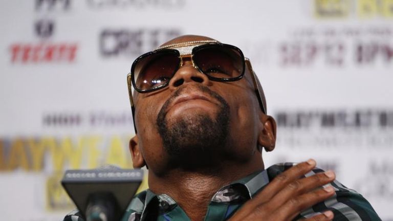 Boxer Floyd Mayweather Jr. watches during a news