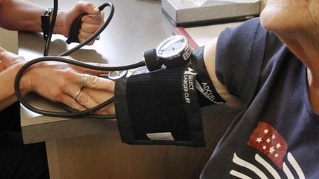 A patient has her blood pressure checked by
