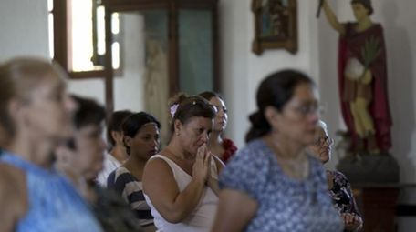 A woman prays as she attends Mass at