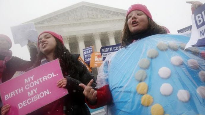 Protestors one wearing a birth control pills costume