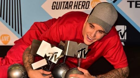 Justin Bieber with his trophies won during the