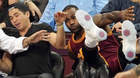 The Cleveland Cavaliers' LeBron James falls into