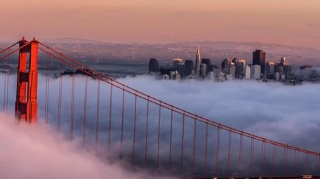 The Golden Gate Bridge, shrouded in clouds, with