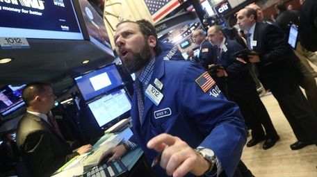 Traders work on the floor of the New