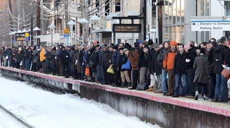 Morning commuters crowd platform as they wait