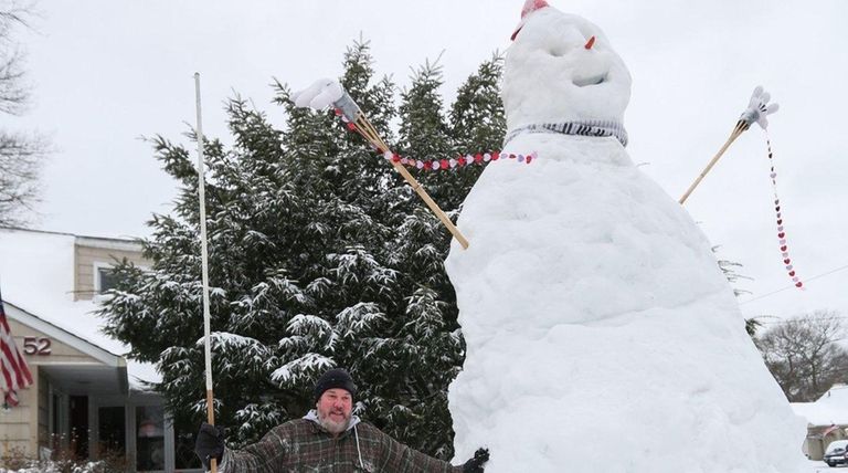 Mike Fregoe stands beside a snowman, over 14-feet