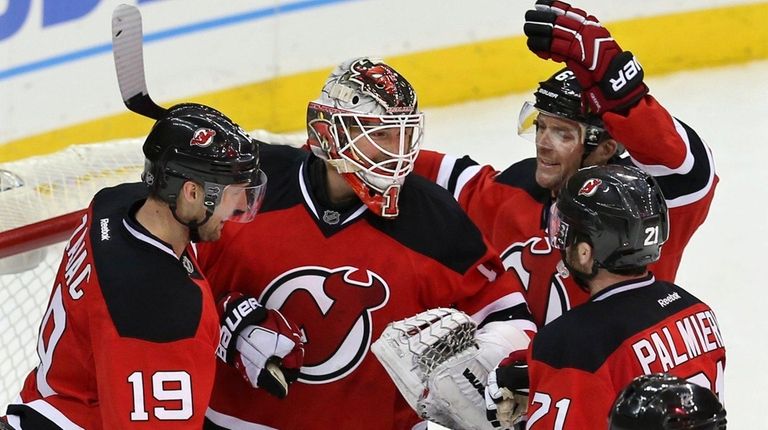 New Jersey Devils goalie Keith Kinkaid, center, is