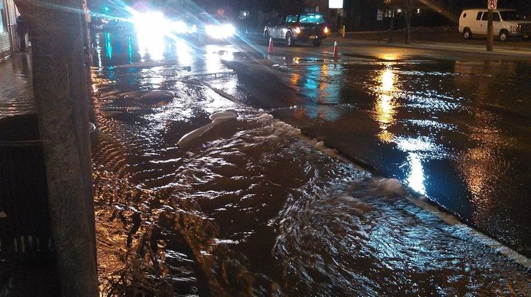 Water from a broken main flows down Merrick