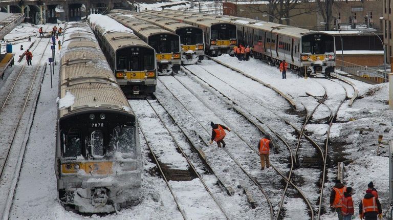 Workers clear snow from Long Island Railroad tracks