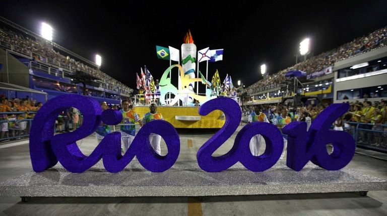 Participants push a Rio 2016 Olympics sign