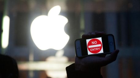 A protestor holds up an iPhone that reads