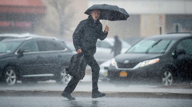 A pedestrian tries to stay dry in Long