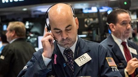Traders work on the floor of the New