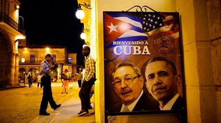 A poster features portraits of Cuba's President Raúl