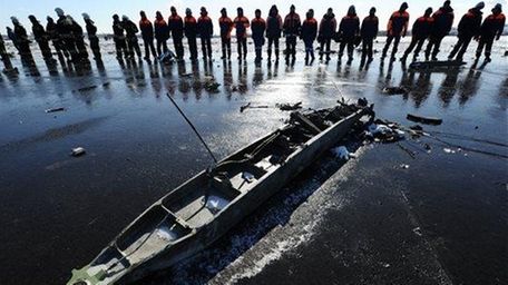Russian Emergency Ministry employees investigate the wreckage of