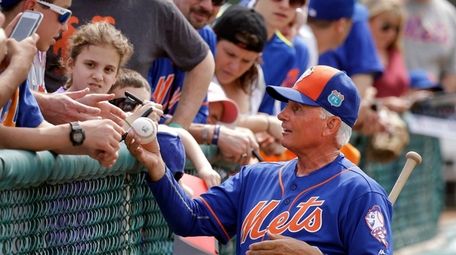 New York Mets manager Terry Collins, right, signs