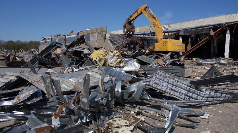 A contractor begins the demolition of the long-vacant