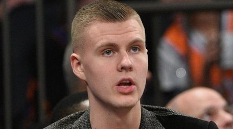 Knicks forward Kristaps Porzingis sits on the bench