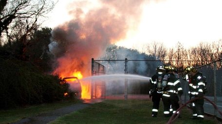 Commack firefighters turn a hose on a burning