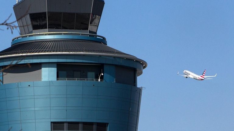 A plane passes the air traffic control tower
