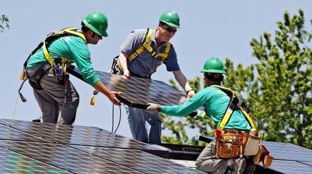 SolarCity employees install a solar panel on a