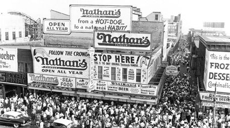 Huge crowds gather on the sidewalk surrounding Nathan's