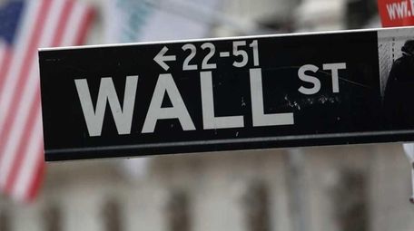 A street sign for Wall Street hangs outside