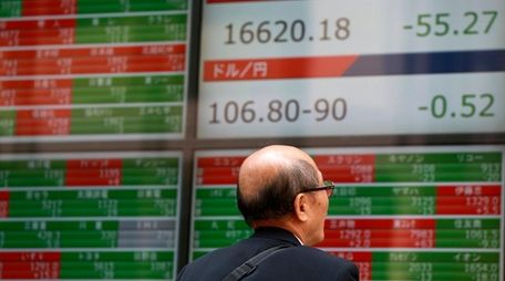 A man watches an electronic stock board showing
