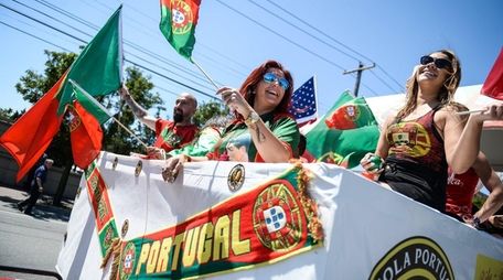 People on the Mineola Portuguese Center float wave
