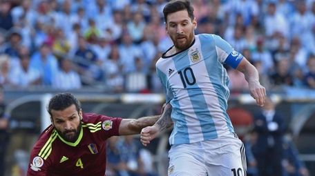 Argentina's Lionel Messi vies for the ball with