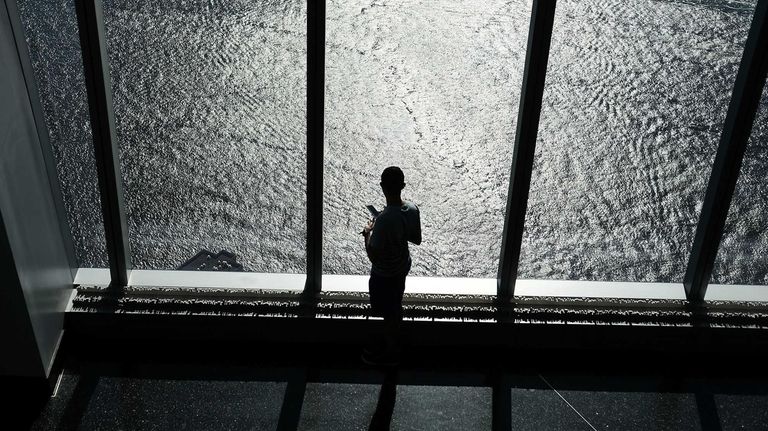A person looks out at the Hudson River