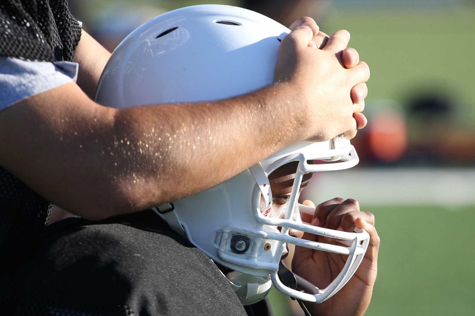 Players do neck stretching during practice at Sewanhaka