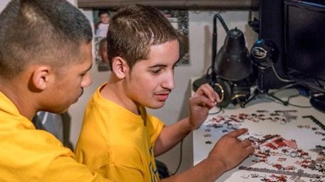 TJ Maldonado, left, helps finish a puzzle with