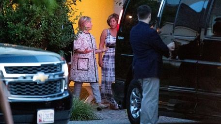 Hillary Clinton, center left, leaves the home of