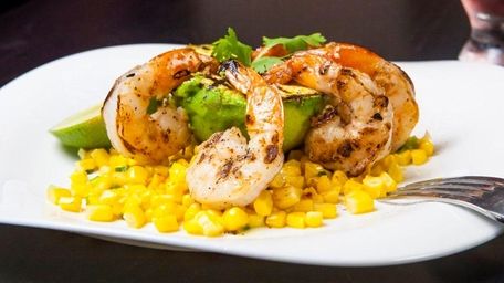 Avocado buoys grilled shrimp on a bed of