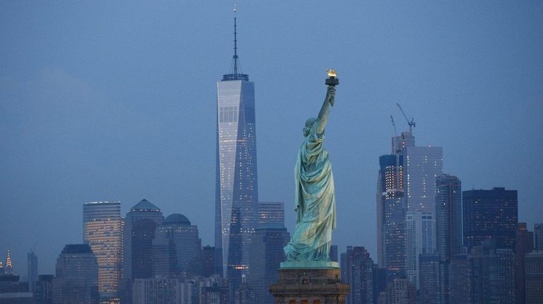 The Statue of Liberty stands in the foreground