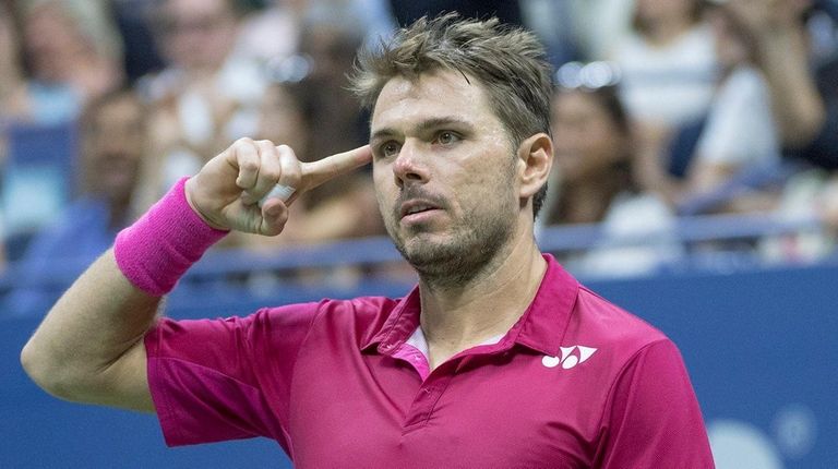 Stan Wawrinka reacts by pointing to his head