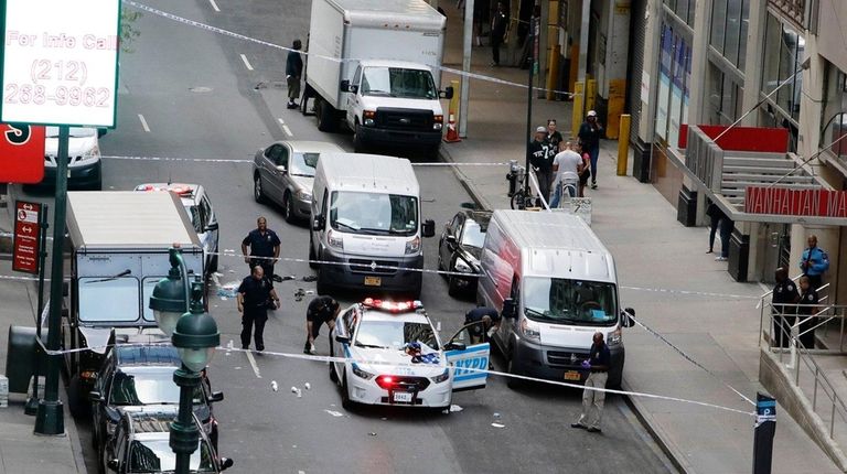 NYPD officers investigate the scene in midtown Manhattan