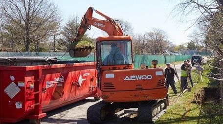 Workers remove contaminated soil suspected of containing polychlorinated