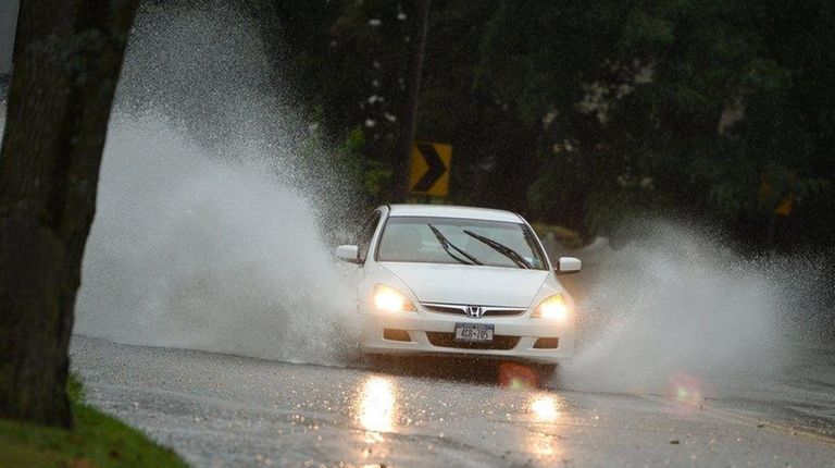 Cars drive through floodwater on Laurel Road in