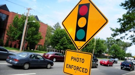 A red-light camera sign on Old Country Road