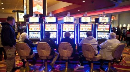 Guests play slot machines at Resorts World Casino