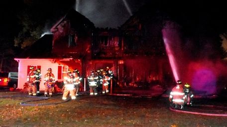 Firefighters battle a blaze that gutted a house