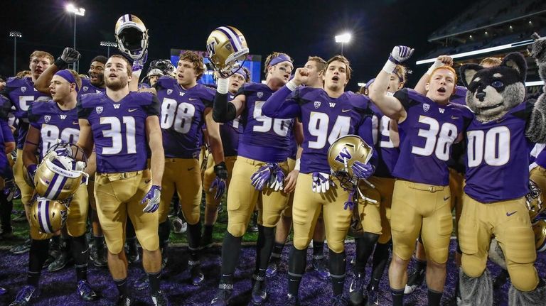 Members of the Washington Huskies celebrate after beating